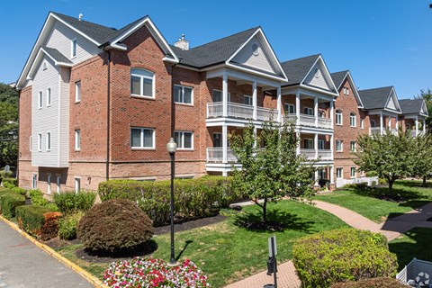 A large red brick building with a white trim and a black roof.