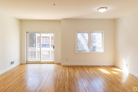 A room with wooden floors and two windows.
