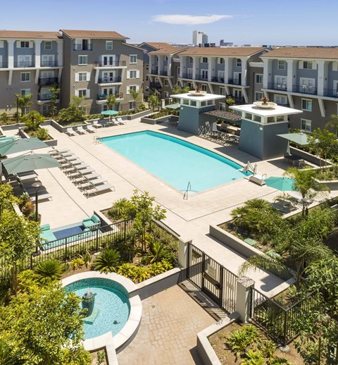A large swimming pool surrounded by a fence and palm trees.