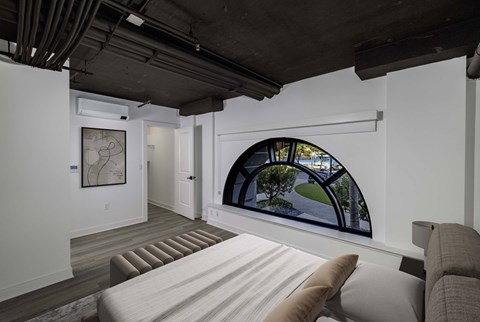 A living room with a couch and a large window.