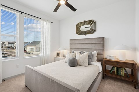 A bedroom with a large bed and a ceiling fan.