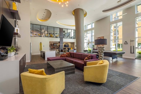 A modern living room with a yellow chair and a red couch.