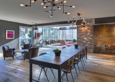 A modern dining room with a long wooden table and chairs.
