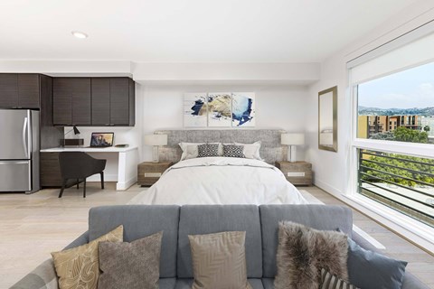 A modern bedroom with a large bed and a grey couch.