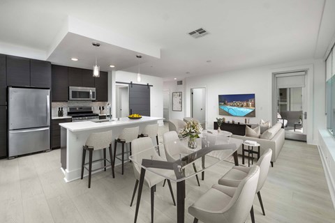 A modern kitchen with a dining table and chairs.