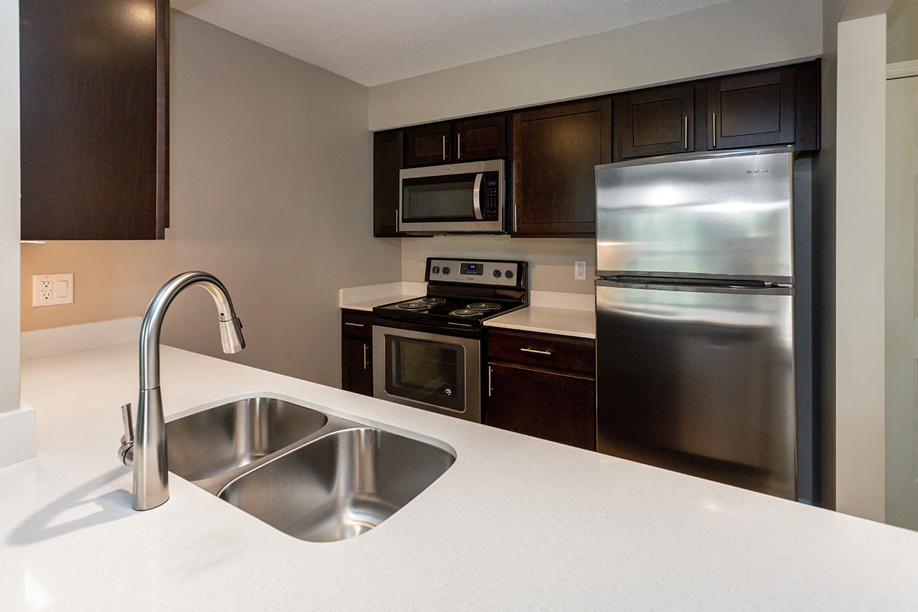 stainless steel sink, oven, and fridge in spacious kitchen