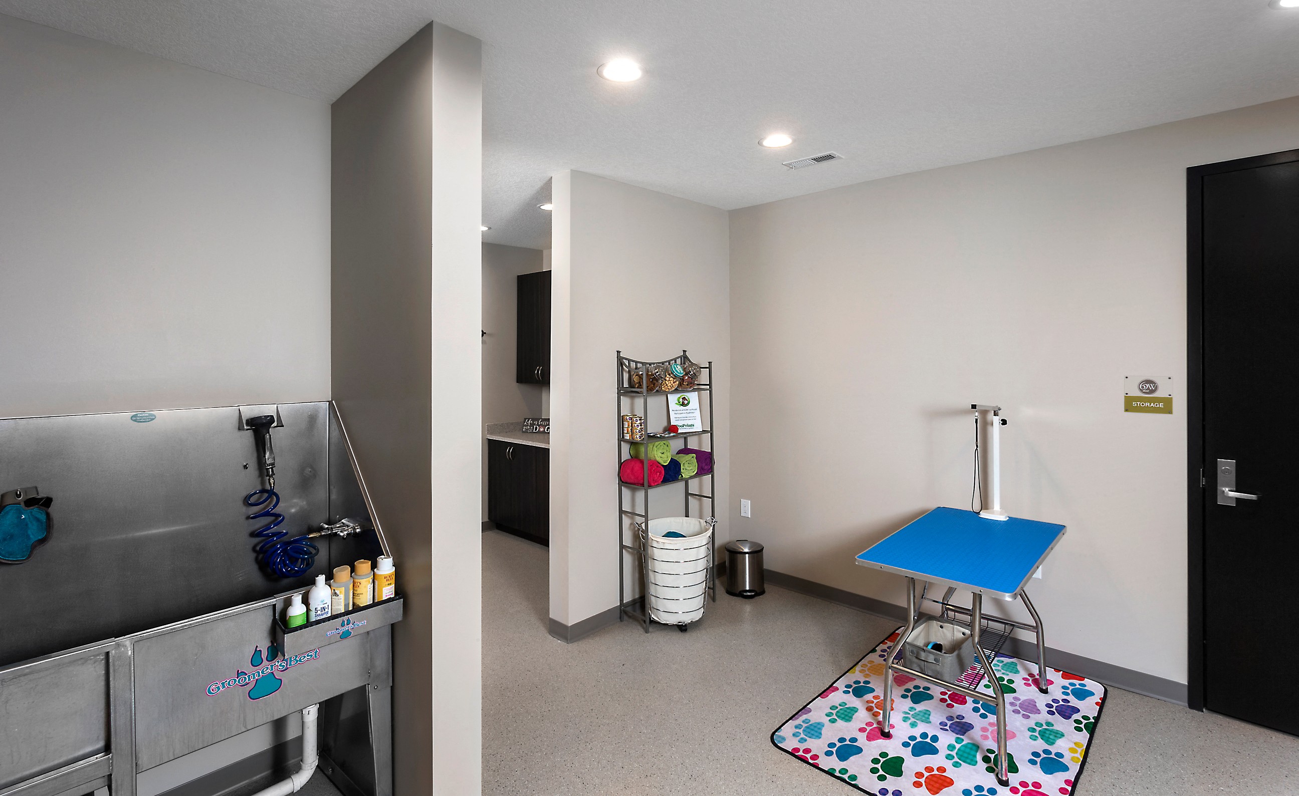 a pet spa with a wash station, pet cages, and a grooming corner