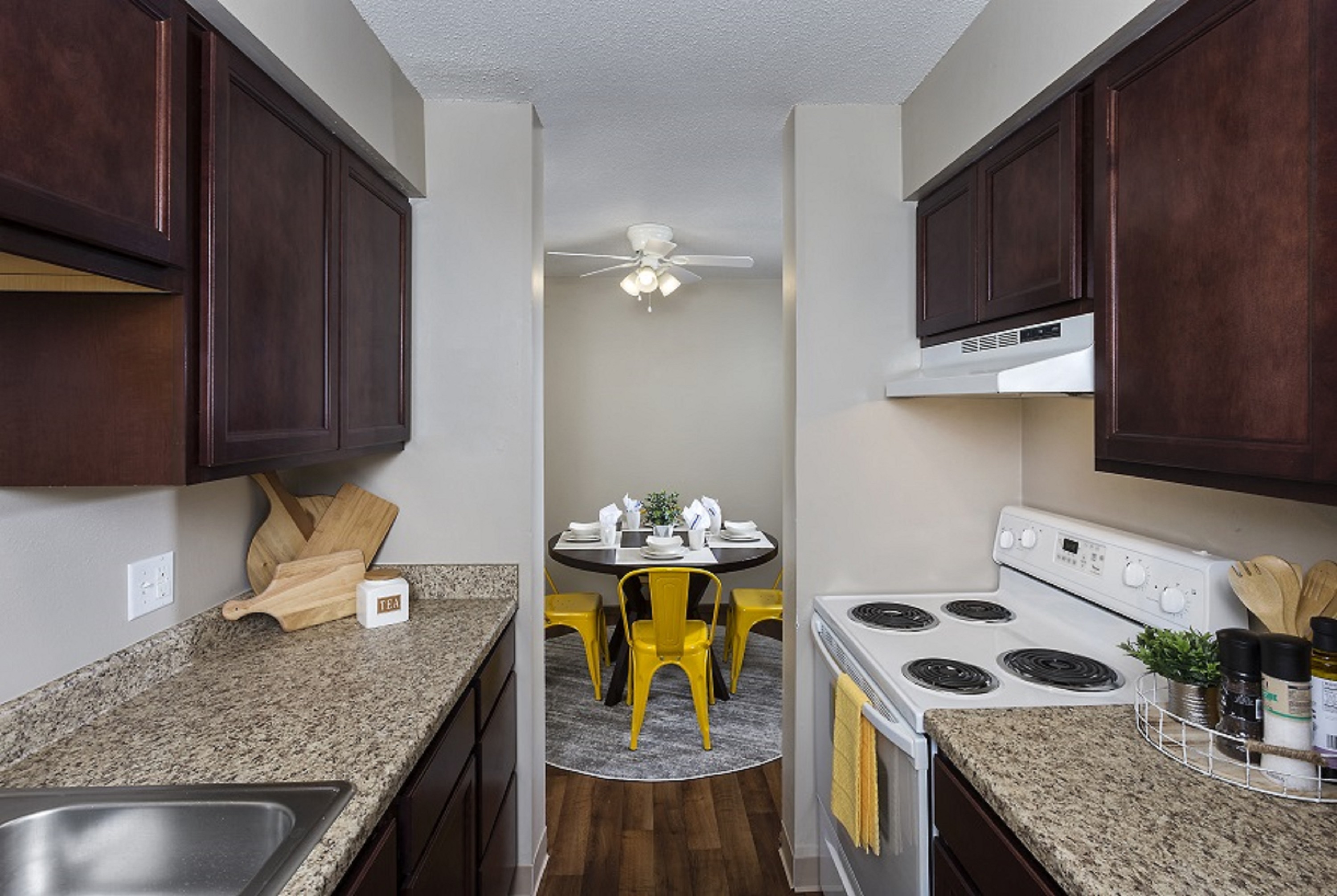 A kitchen with brown cabinets and a white stove top oven.