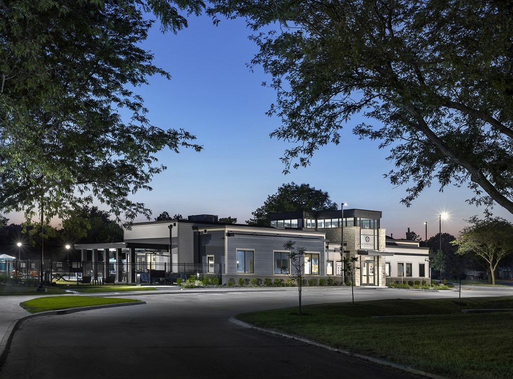 modern clubhouse at sunset with large windows and navy siding
