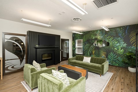 A living room with a green couch and a fireplace.