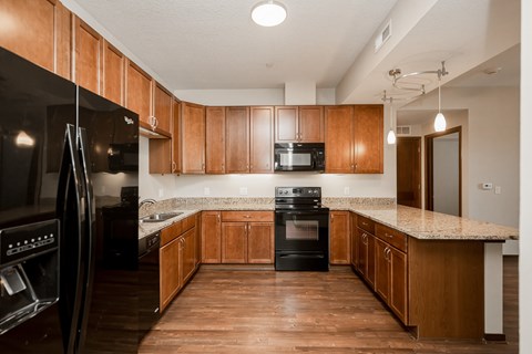 A kitchen with wooden cabinets and black appliances.