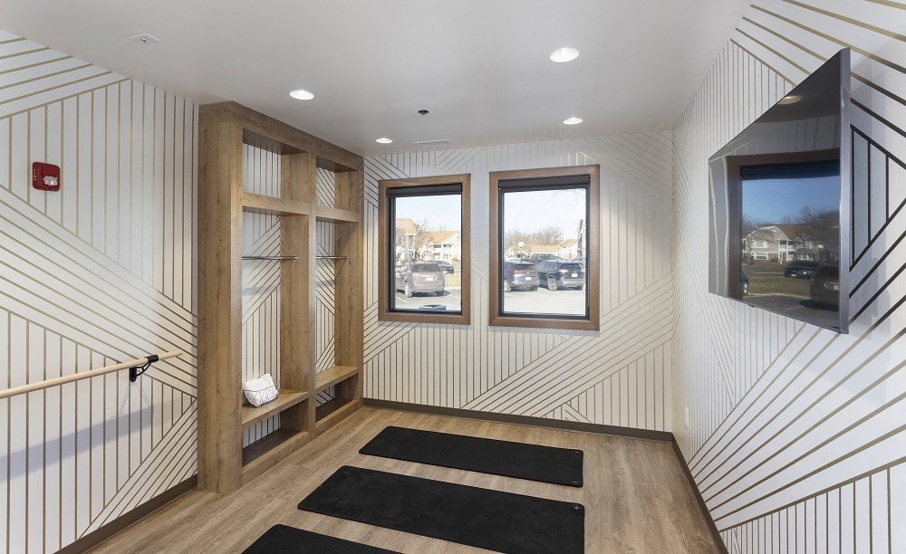 yoga studio with yoga mats, cabinets, and large mirrors