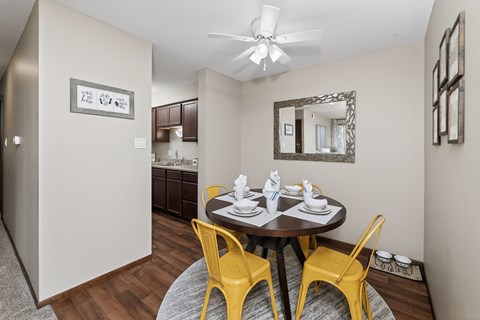 A dining room with a round table and yellow chairs.