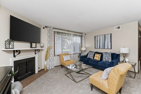 A living room with a fireplace, a blue couch, and a television.