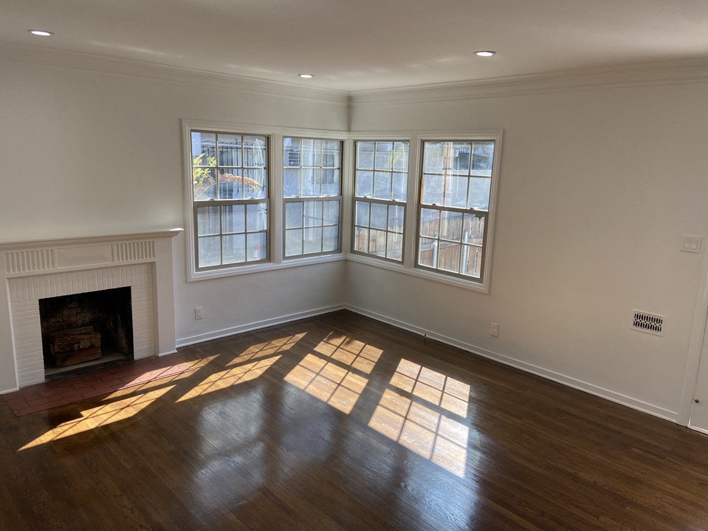 an empty living room with a fireplace and windows