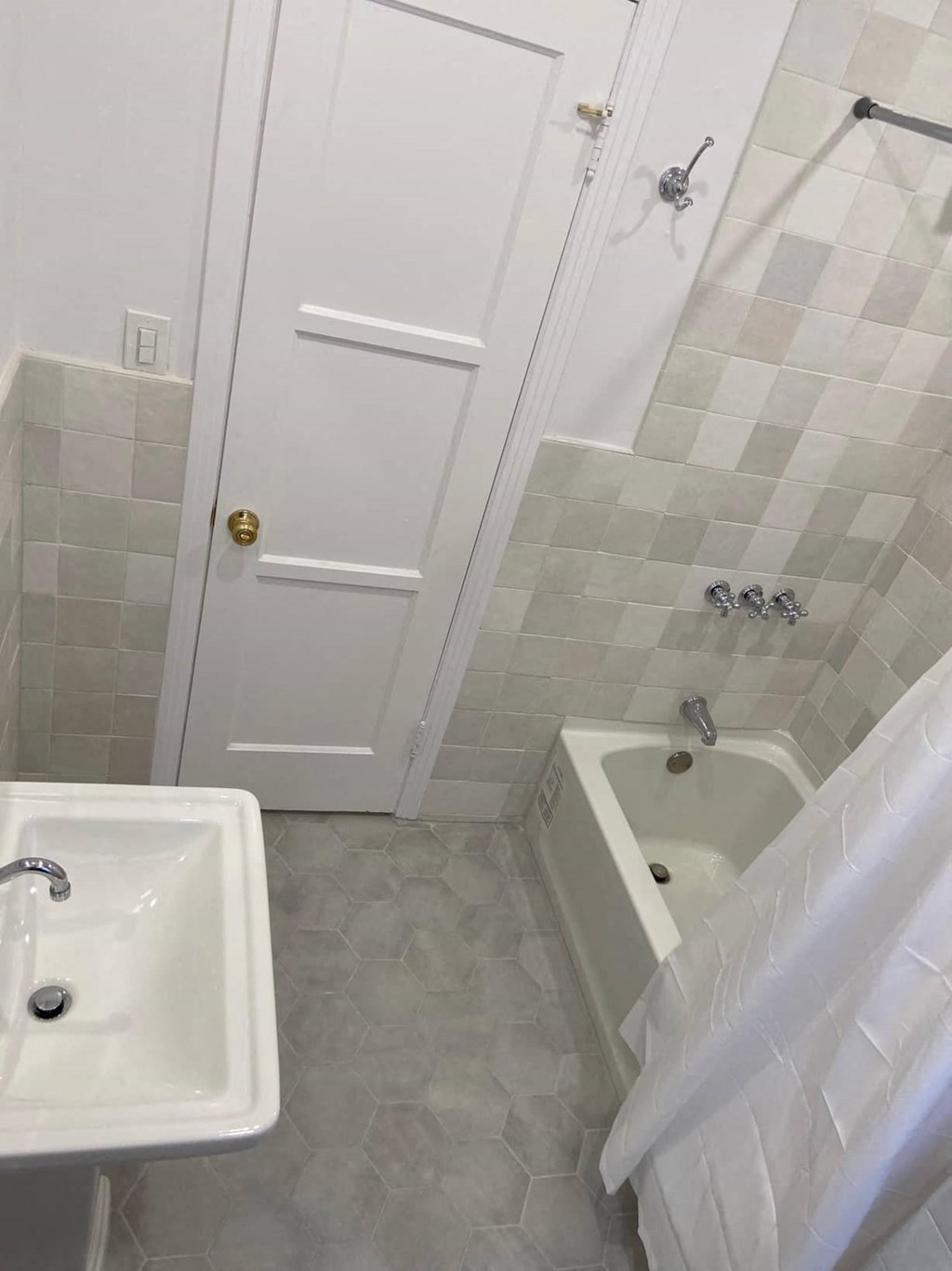 a white bathroom with a tub and a sink
