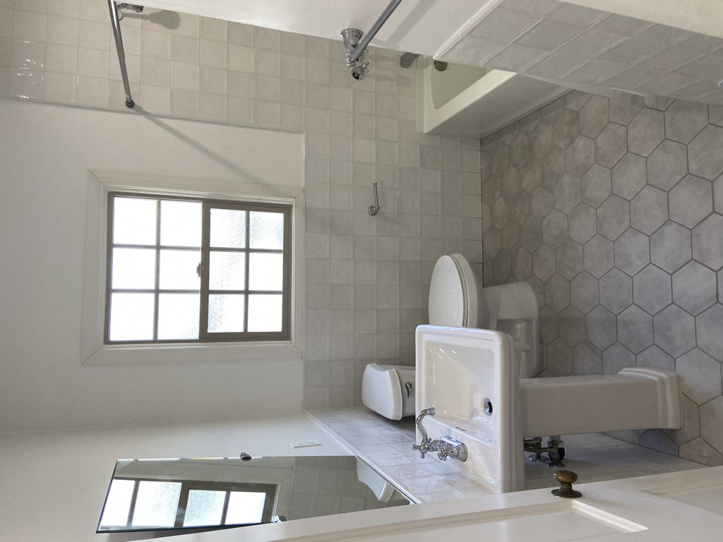 a bathroom with a toilet and a sink and a window