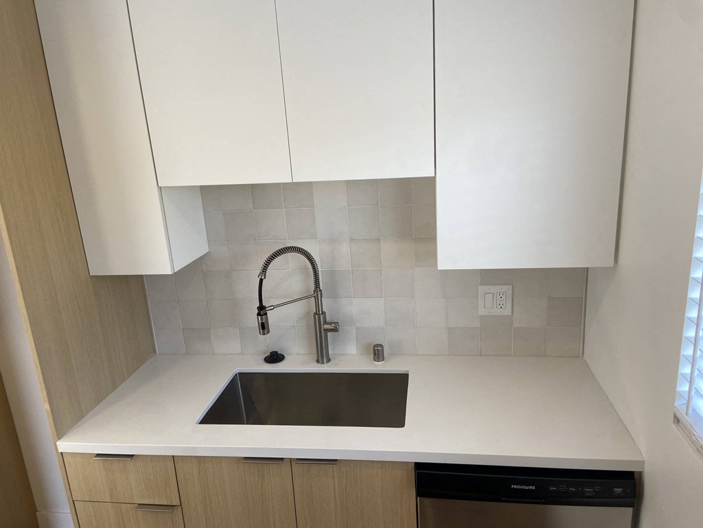 a new kitchen with white cabinets and a sink