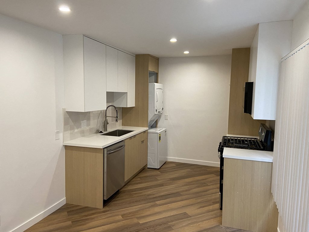 an empty kitchen with a stove and a sink