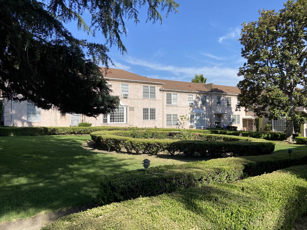 a large building with a lawn and trees in front of it