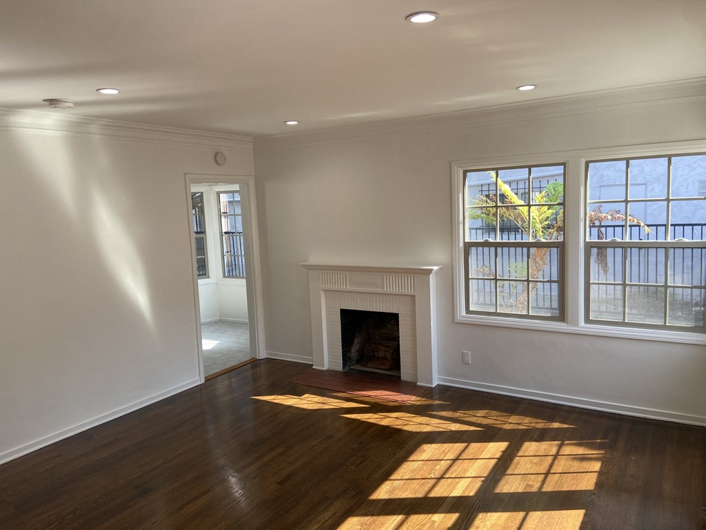 an empty living room with a fireplace and windows