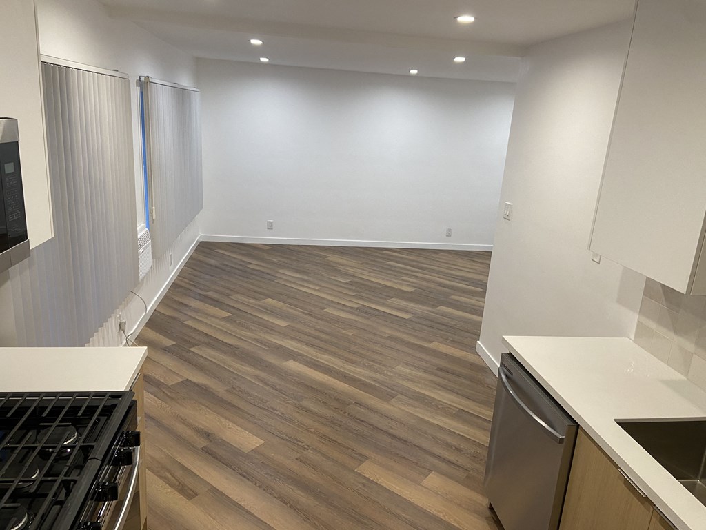 a kitchen and living room with wood floors and white walls
