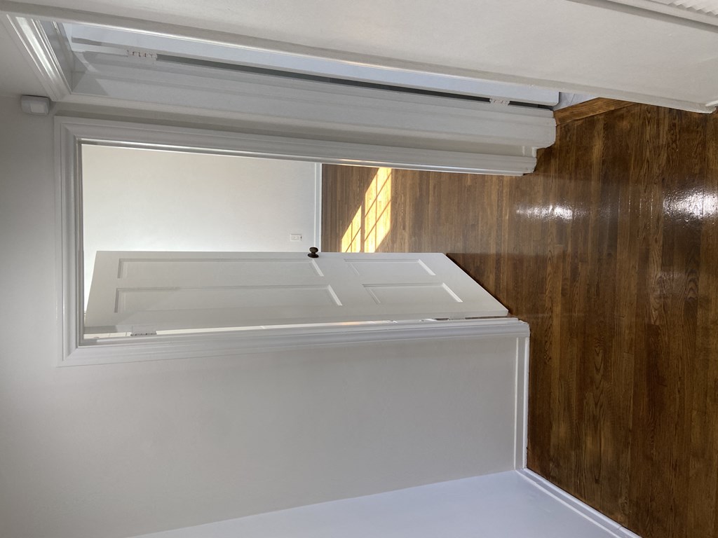 an empty room with a window and a white radiator