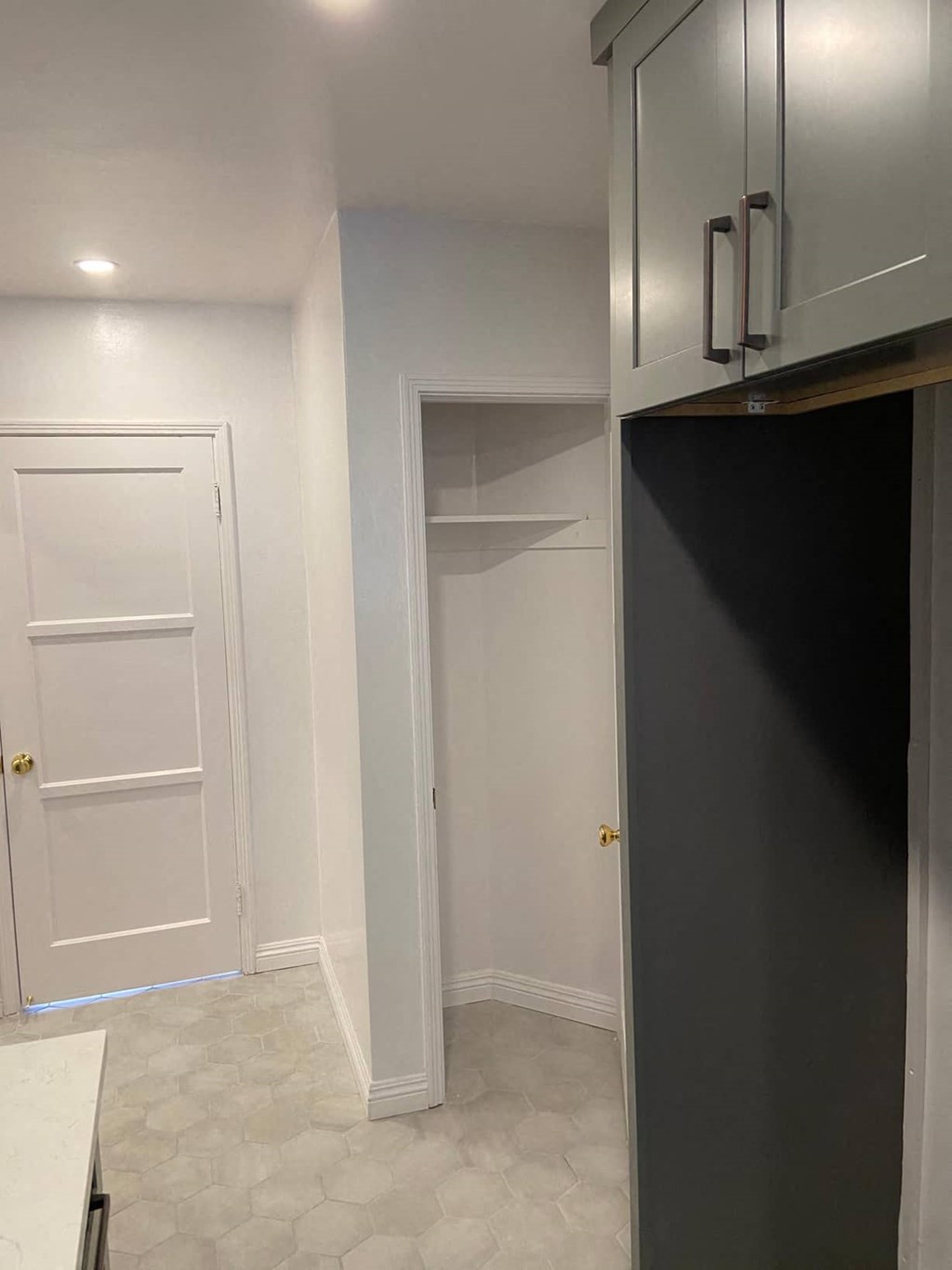 a small kitchen with a door to a closet