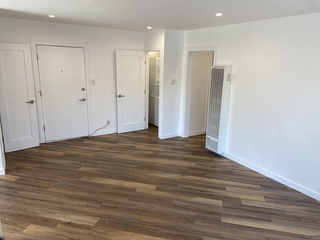 a renovated living room with wood floors and white walls
