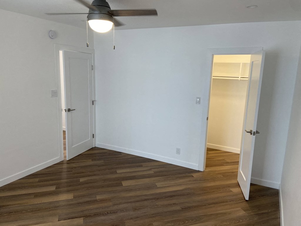 a room with a wood floor and a ceiling fan
