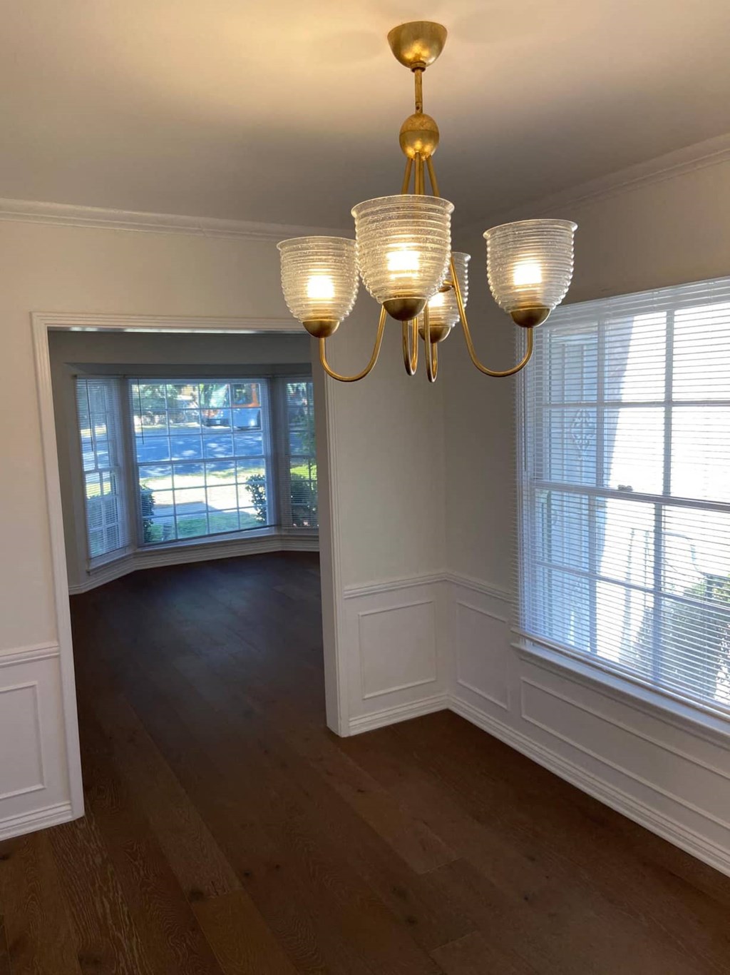 a view of a dining room with a chandelier and large windows