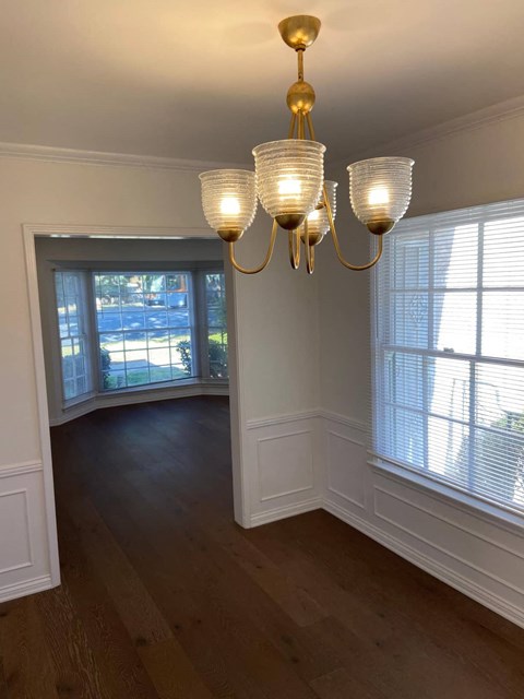 a view of a dining room with a chandelier and large windows