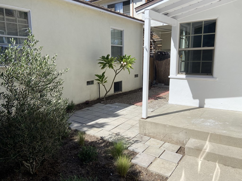 a patio in front of a white house with a white door