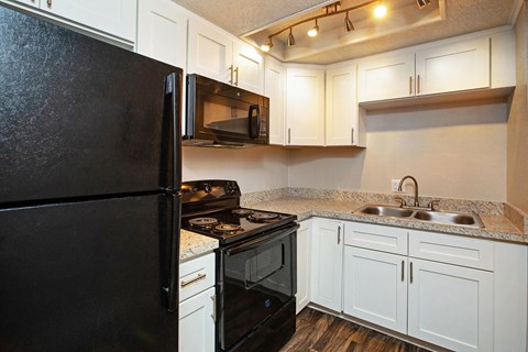 a kitchen with black appliances and white cabinets