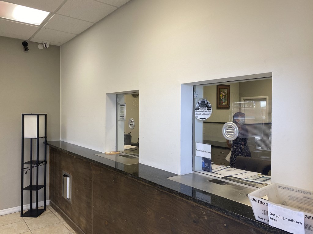 a reception desk with a large window and a small window next to it at Colonial Drive Apartments, Orlando, FL