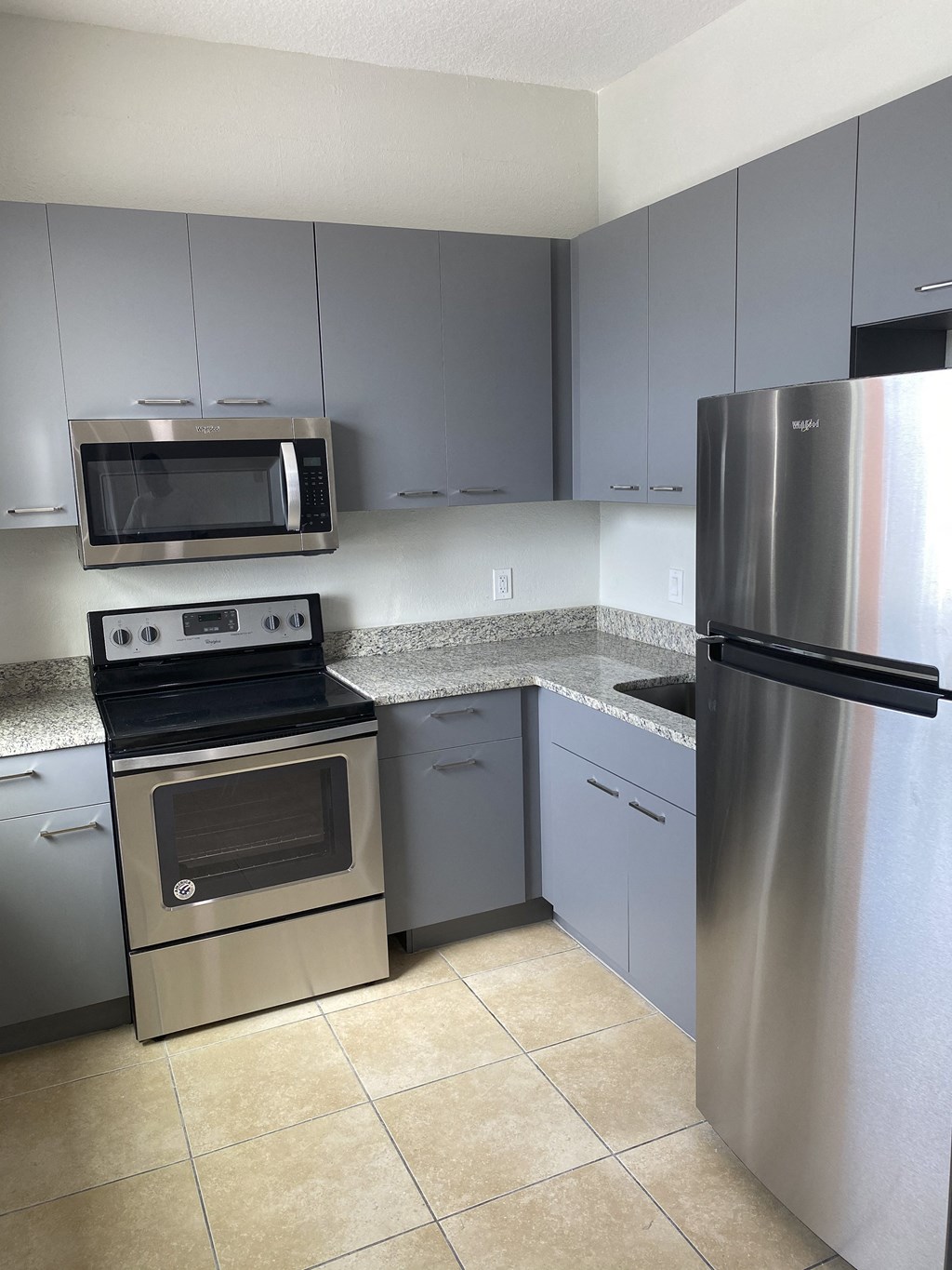 a kitchen with gray cabinets and stainless steel appliances at Colonial Drive Apartments, Orlando, FL 32808