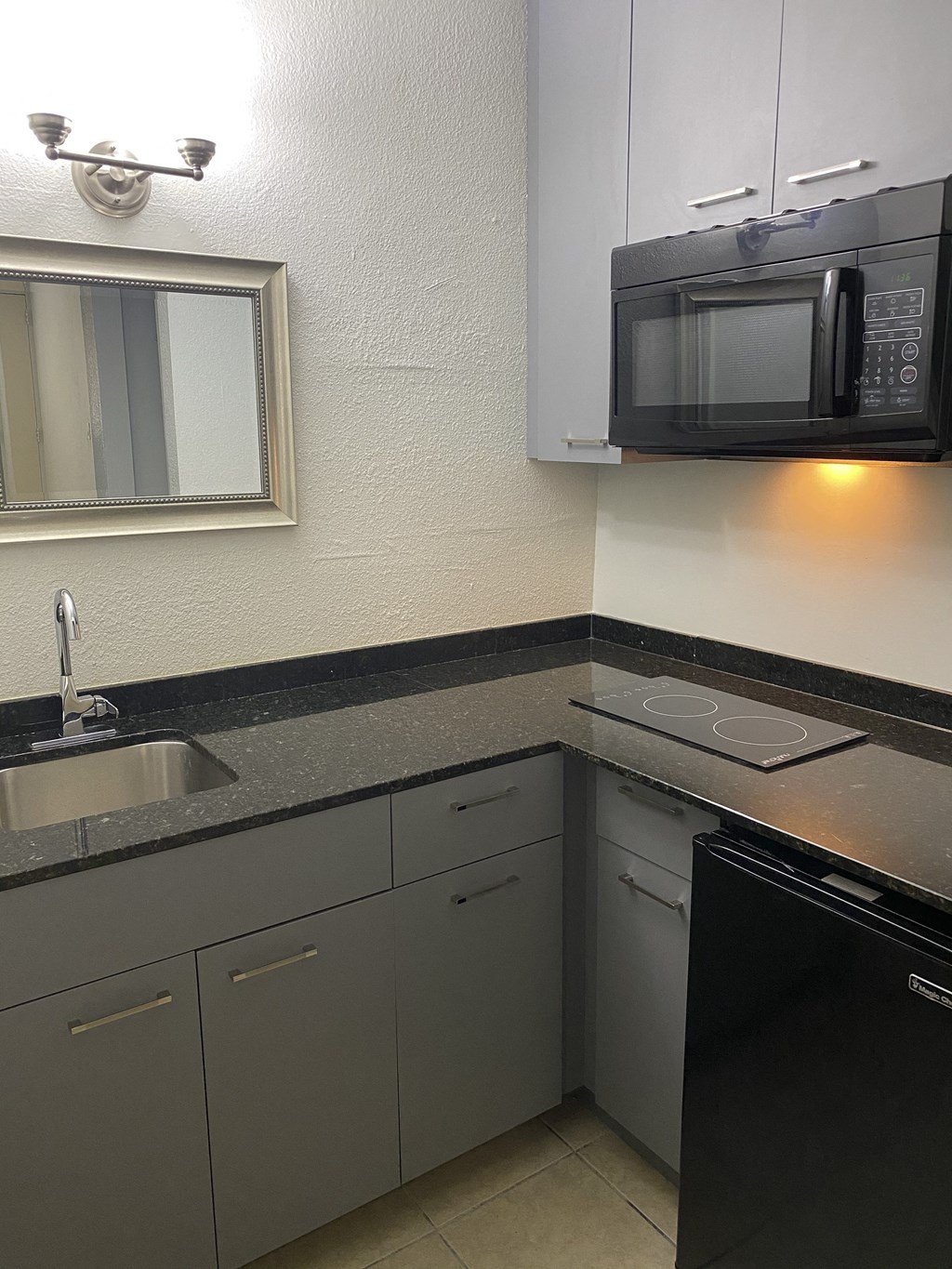 a kitchen with a sink and a microwave a kitchen with a sink and a microwave at Colonial Apartments, Orlando Florida