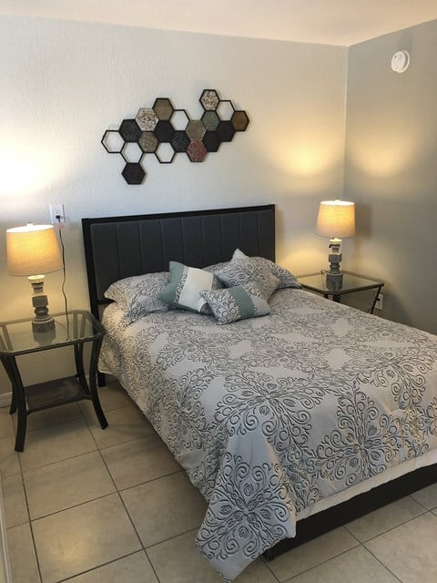 a bedroom with a bed and two night stands at Colonial Apartments, Orlando Florida