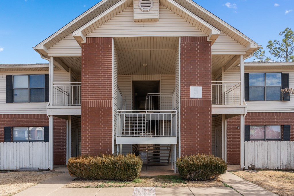 an exterior view of a brick apartment building with a balcony