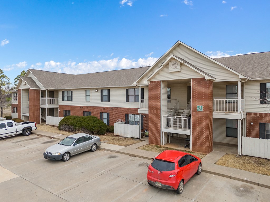 an apartment building with two cars parked in front of it