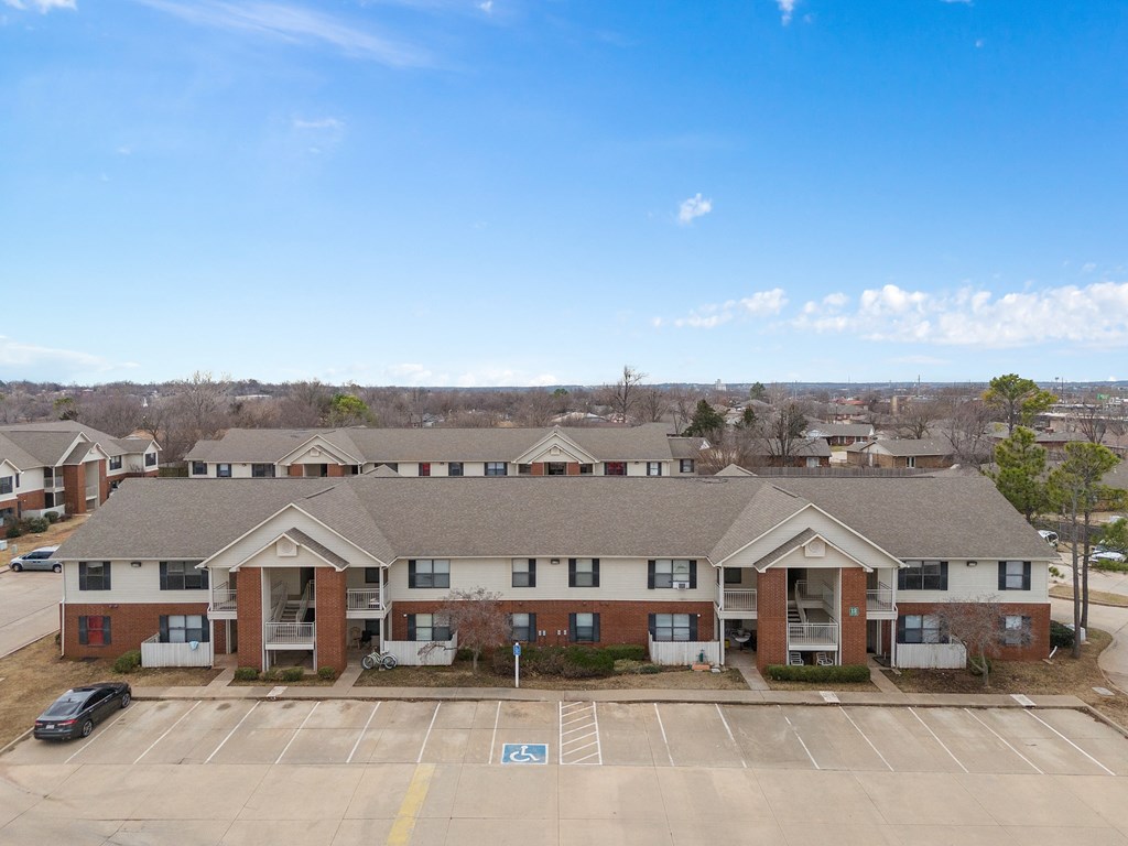 an aerial view of an apartment complex with a parking lot