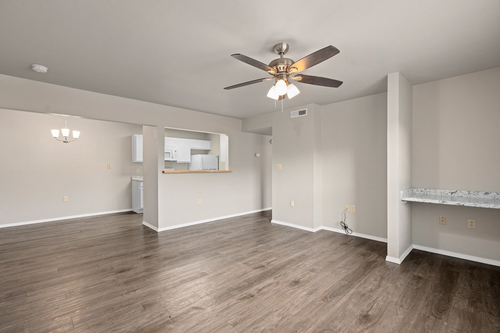 an empty living room with white walls and a ceiling fan