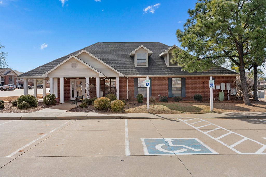 a brick house with a driveway and a parking lot