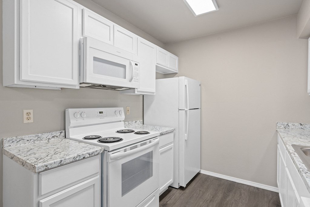 a kitchen with white appliances and white cabinets