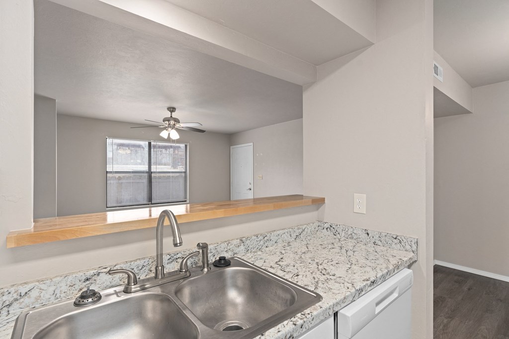 an empty kitchen with two sinks and a window