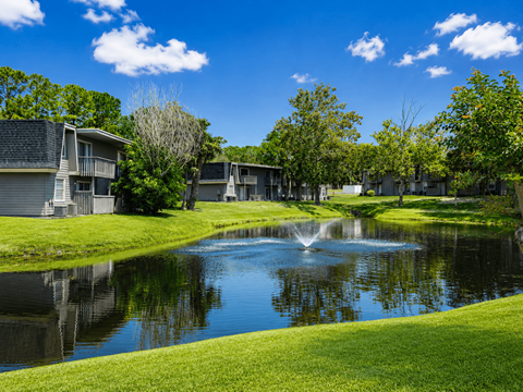 A serene lake in a residential area with houses on the side.