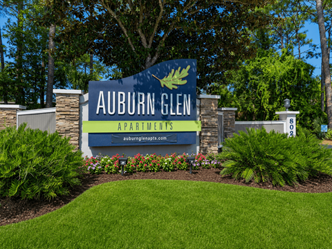 A sign for Auburn Glen Apartments is displayed in front of a building.