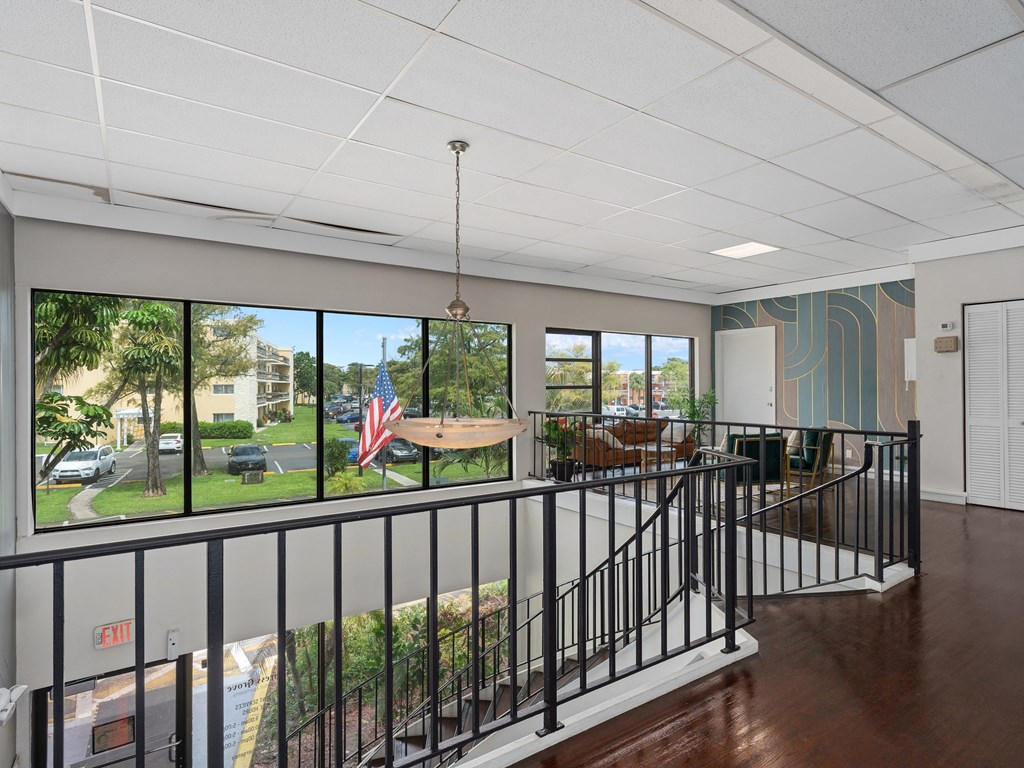 a lobby with a view of a yard and a table and chairs