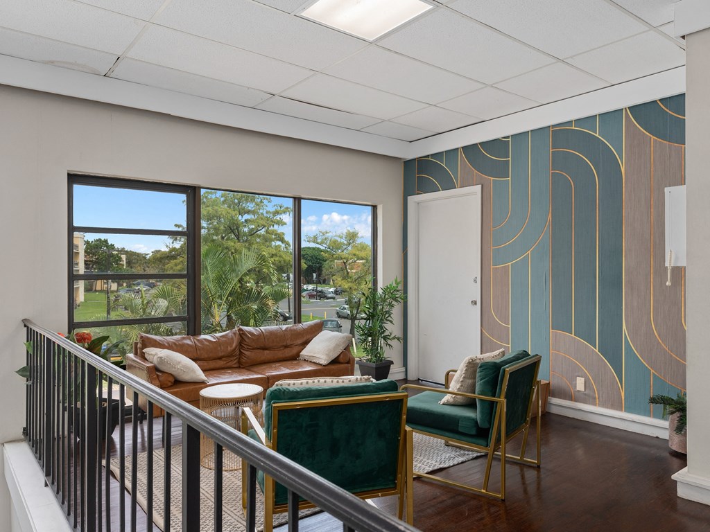 a living room with a couch and chairs on a balcony
