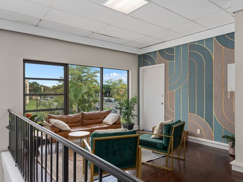 a living room with a couch and chairs on a balcony  at Cypress Grove, Lauderhill, FL